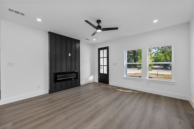 unfurnished living room featuring ceiling fan, a fireplace, and hardwood / wood-style floors