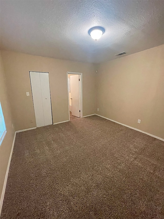 unfurnished bedroom with a closet, a textured ceiling, and carpet floors