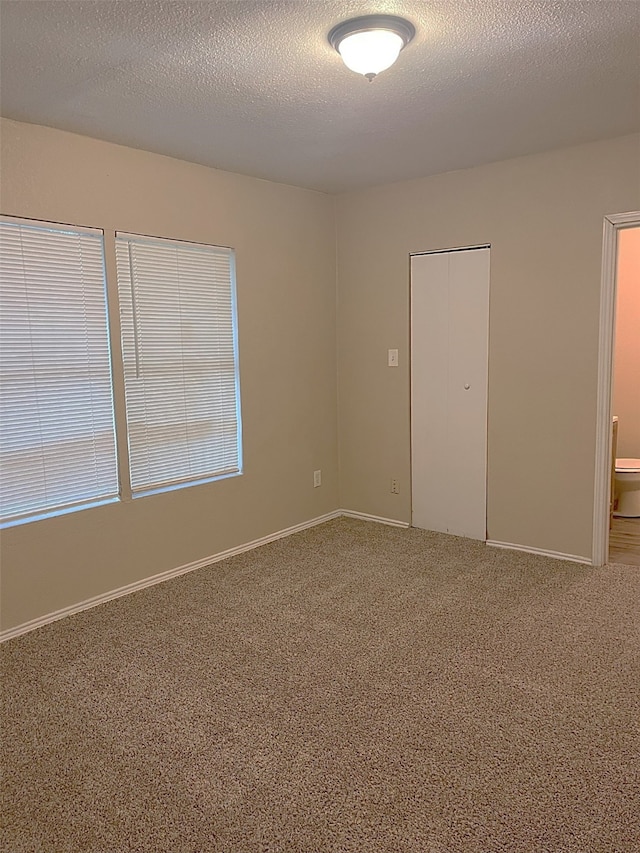 carpeted spare room with a textured ceiling