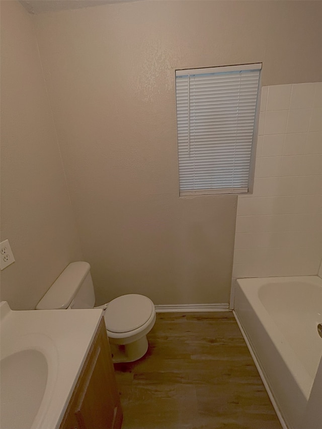 bathroom with vanity, hardwood / wood-style floors, toilet, and a tub