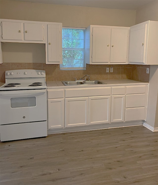 kitchen with light wood-type flooring, white cabinetry, white electric range oven, and sink