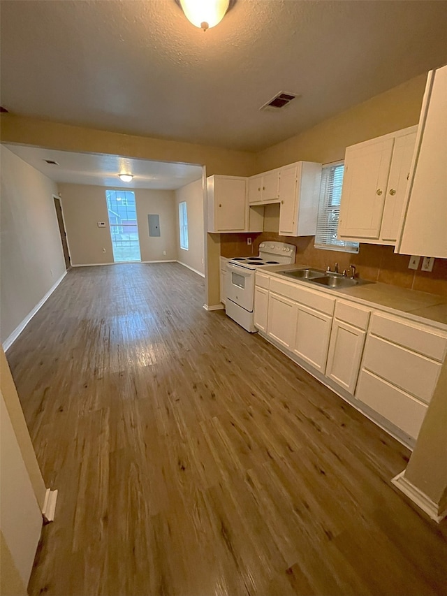 kitchen with white cabinetry, white electric stove, wood-type flooring, a textured ceiling, and sink