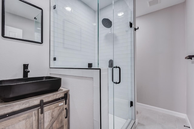 full bathroom featuring visible vents, baseboards, a stall shower, and vanity