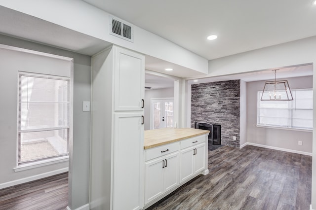 kitchen with pendant lighting, a fireplace, dark hardwood / wood-style flooring, and white cabinetry