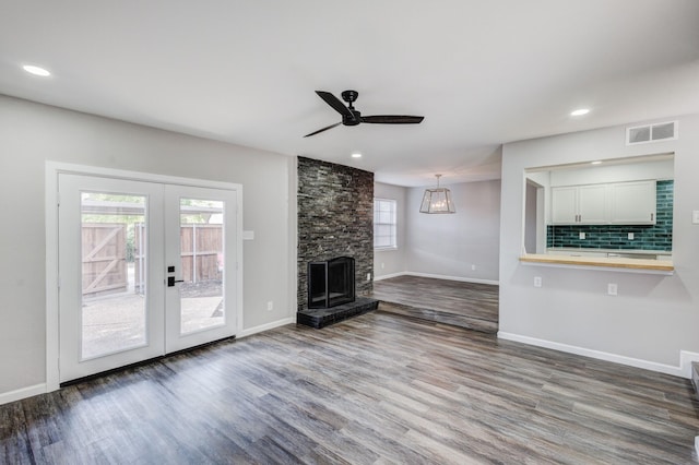 unfurnished living room featuring dark wood finished floors, french doors, visible vents, and a ceiling fan