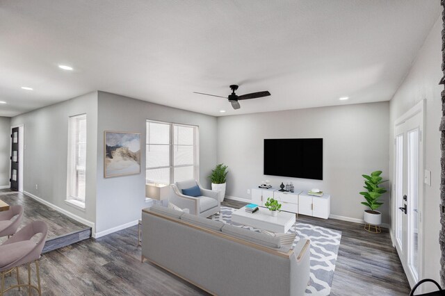 living room featuring ceiling fan and dark hardwood / wood-style floors