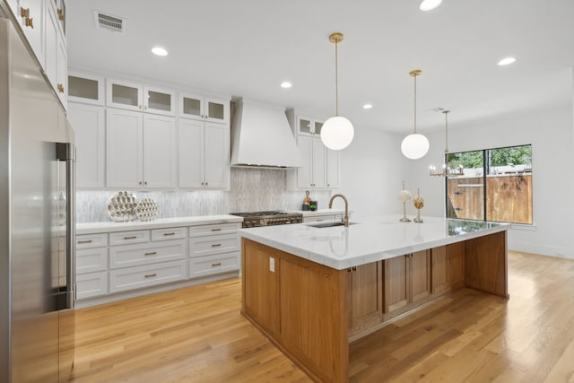 kitchen with premium range hood, white cabinetry, a spacious island, and stainless steel appliances