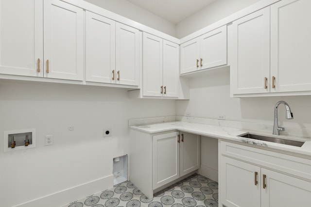 clothes washing area with cabinets, hookup for a washing machine, hookup for an electric dryer, and sink