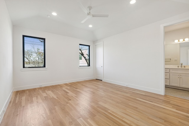 unfurnished room with ceiling fan, light hardwood / wood-style floors, sink, and vaulted ceiling