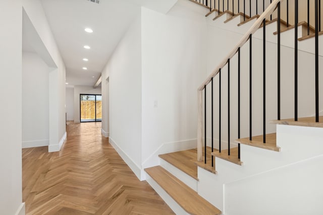 staircase featuring parquet flooring