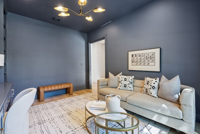 living room with light wood-type flooring and an inviting chandelier