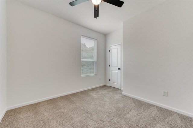 carpeted spare room with ceiling fan