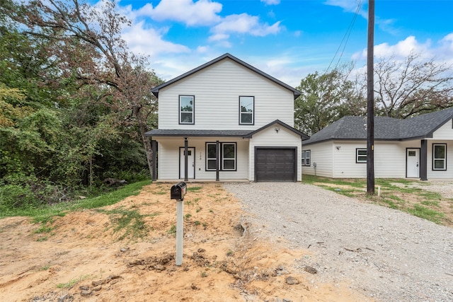 view of front property with a porch and a garage