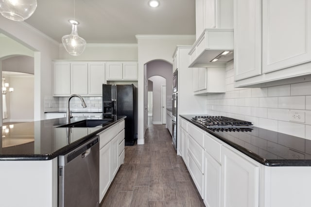 kitchen featuring decorative light fixtures, a kitchen island with sink, white cabinetry, appliances with stainless steel finishes, and dark hardwood / wood-style flooring