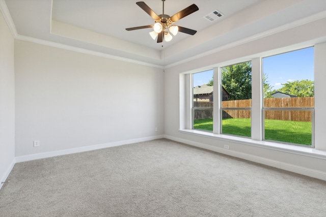 empty room featuring a raised ceiling, visible vents, and baseboards