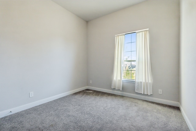 spare room featuring lofted ceiling and carpet