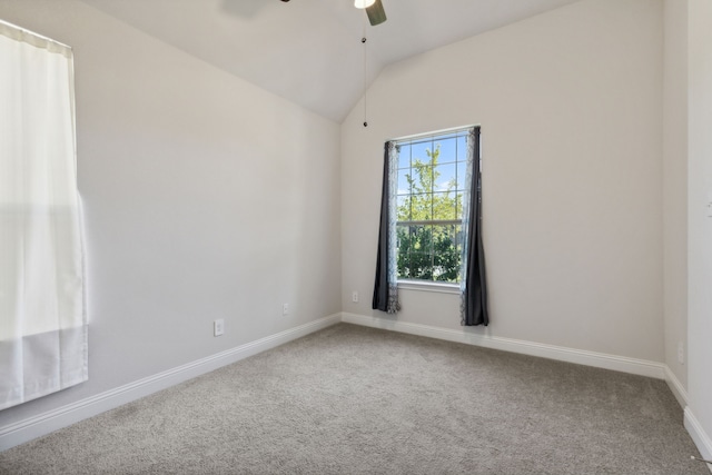 carpeted spare room featuring vaulted ceiling, a ceiling fan, and baseboards