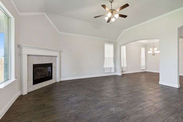 unfurnished living room with crown molding, ceiling fan with notable chandelier, a tiled fireplace, and dark hardwood / wood-style flooring