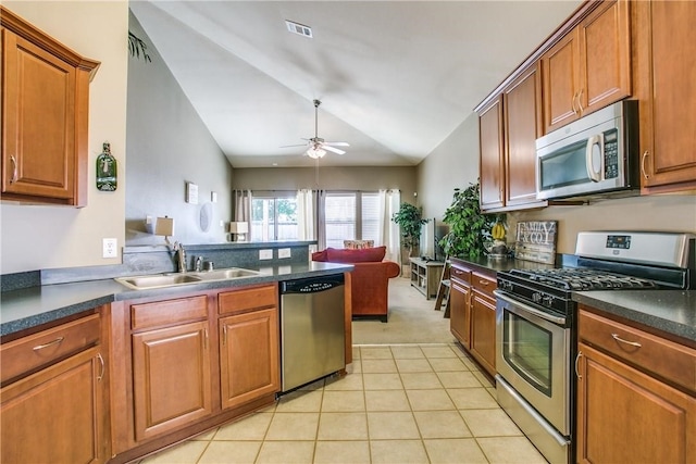 kitchen featuring ceiling fan, lofted ceiling, light tile patterned floors, sink, and appliances with stainless steel finishes