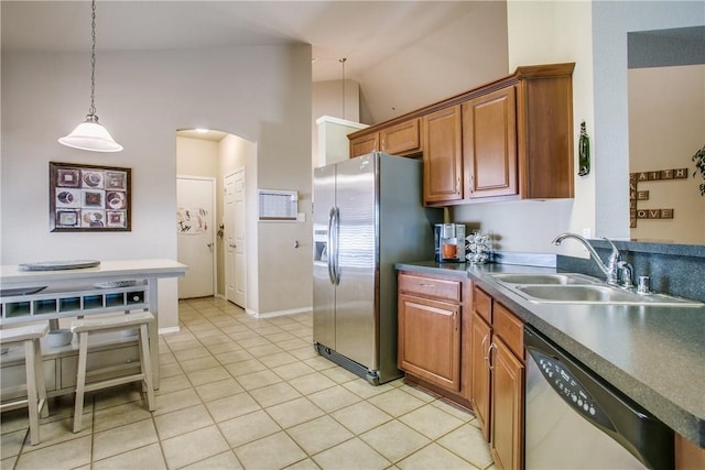 kitchen featuring appliances with stainless steel finishes, high vaulted ceiling, light tile patterned floors, decorative light fixtures, and sink