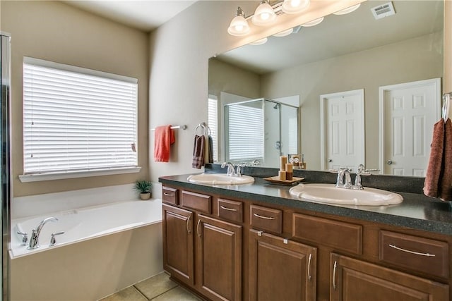 bathroom featuring tile patterned flooring, vanity, plus walk in shower, and a wealth of natural light