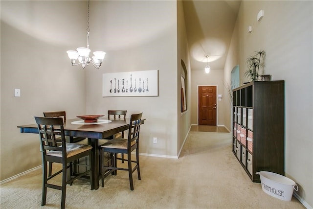 dining room featuring a notable chandelier, a towering ceiling, and light colored carpet