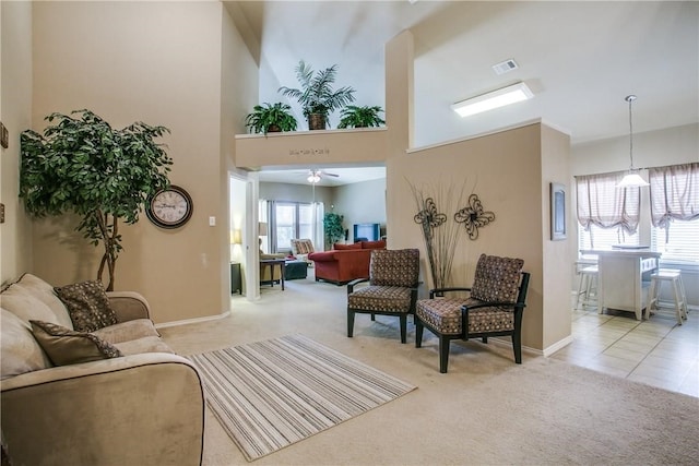 carpeted living room with a towering ceiling and ceiling fan