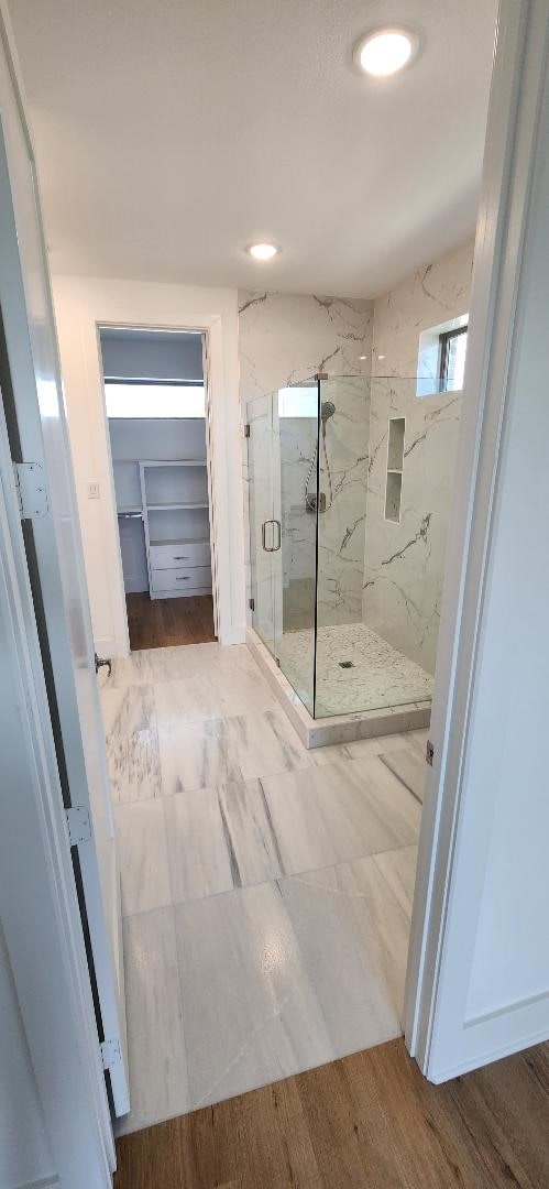 bathroom with hardwood / wood-style flooring and an enclosed shower