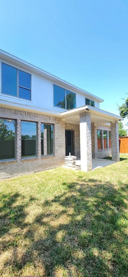 rear view of house with a lawn and a patio area