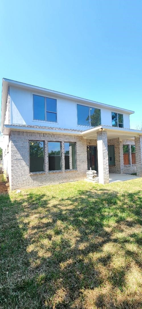 rear view of property with a lawn and a patio area