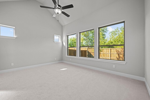 carpeted spare room with ceiling fan and high vaulted ceiling