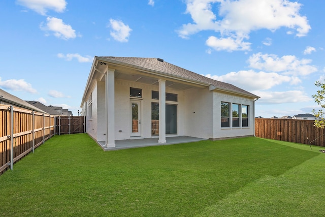 rear view of house with a yard and a patio