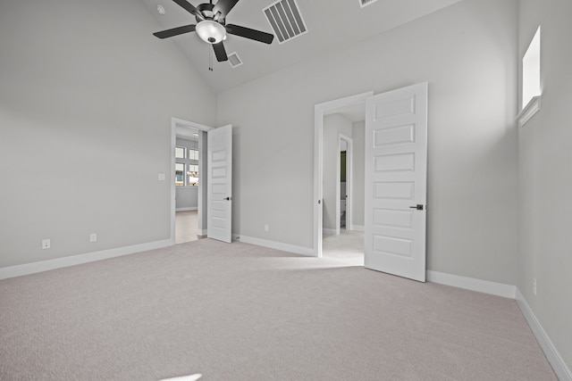 unfurnished bedroom featuring ceiling fan, light colored carpet, and high vaulted ceiling