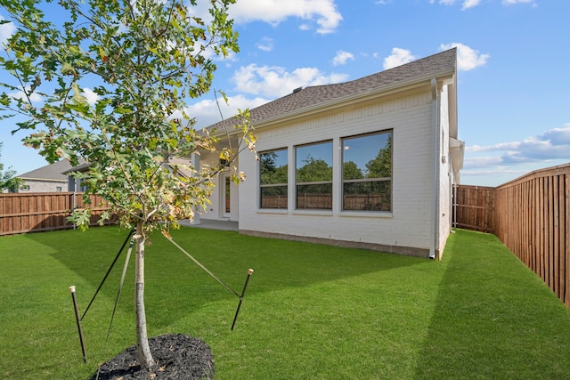 rear view of property featuring a lawn