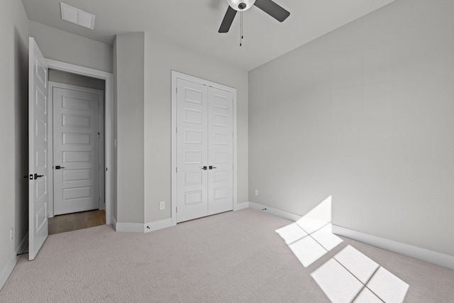 unfurnished bedroom featuring ceiling fan, a closet, and light carpet