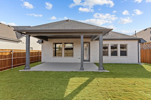 back of property with a patio area and a lawn