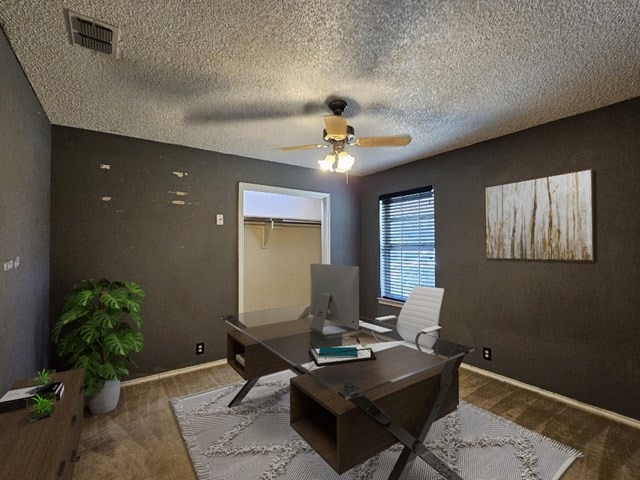 carpeted office with ceiling fan and a textured ceiling