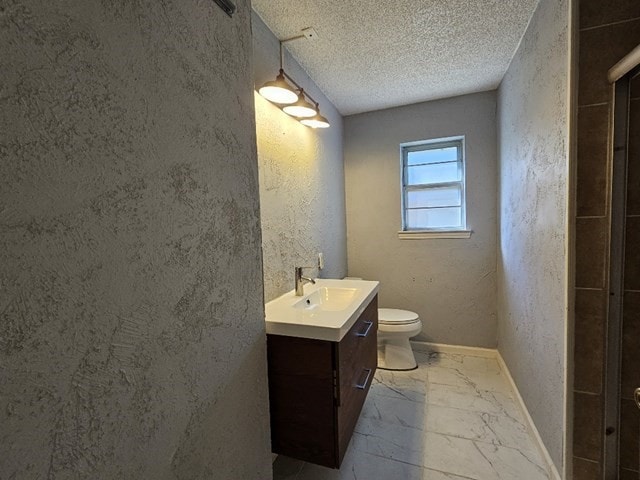 bathroom featuring vanity, toilet, and a textured ceiling