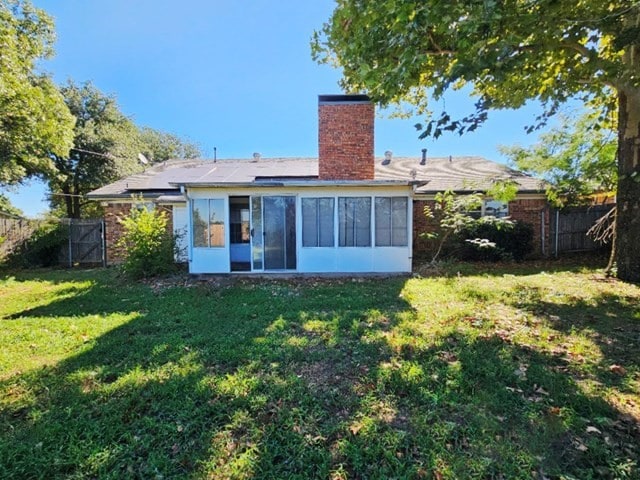 rear view of property with a lawn