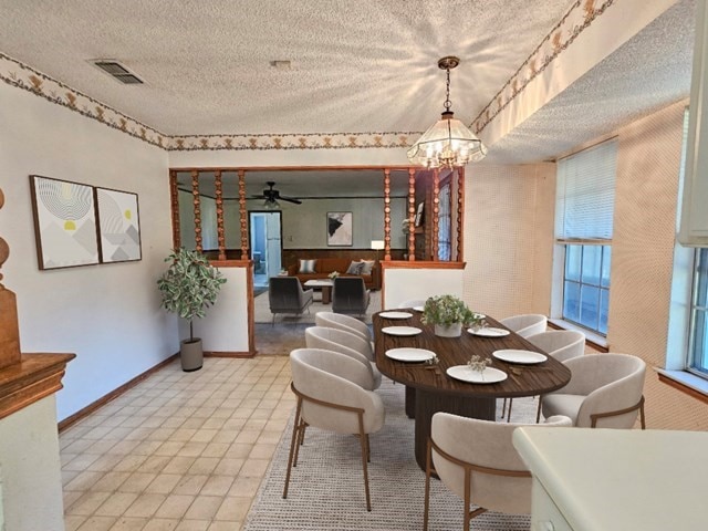 tiled dining area featuring a textured ceiling, ceiling fan with notable chandelier, and a healthy amount of sunlight