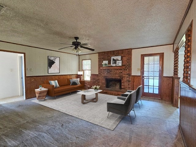 carpeted living room featuring a textured ceiling, a fireplace, wood walls, and ceiling fan