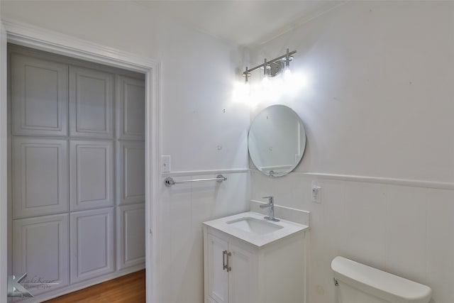 bathroom with wood-type flooring, vanity, and toilet