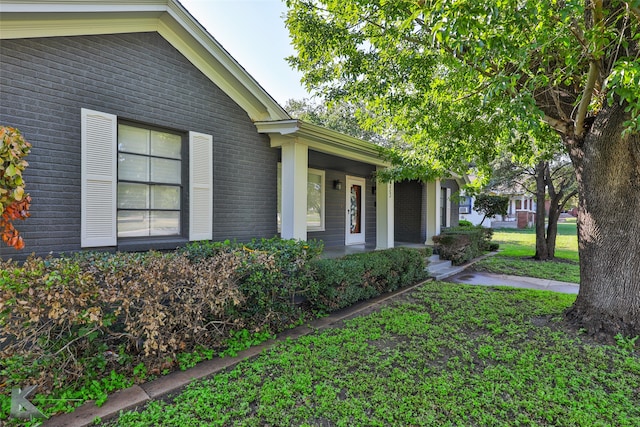 view of side of home featuring a porch and a yard