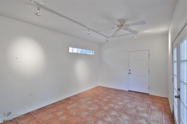 empty room with ceiling fan, light tile patterned flooring, and rail lighting