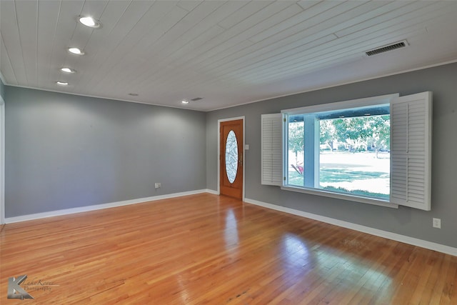 unfurnished room with light wood-type flooring and wooden ceiling