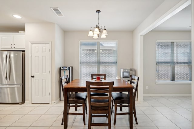 tiled dining area with a notable chandelier