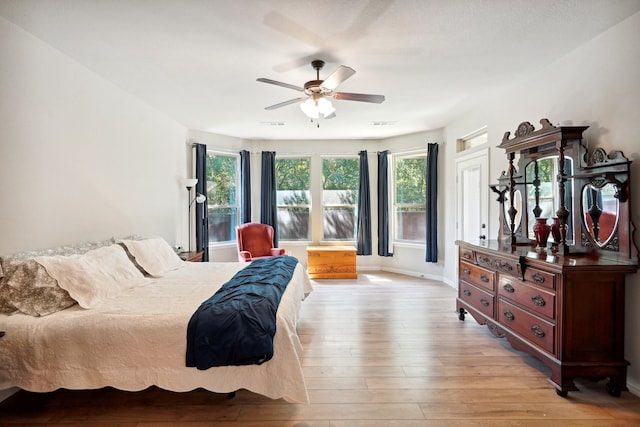 bedroom featuring light hardwood / wood-style flooring, multiple windows, and ceiling fan