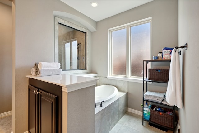 bathroom with tile patterned flooring, independent shower and bath, plenty of natural light, and vanity