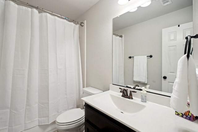 bathroom featuring curtained shower, vanity, and toilet