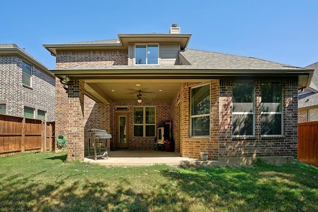 rear view of house featuring ceiling fan, a patio area, and a yard